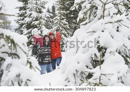 Austria,Salzburg Country,Flachau,Young man and woman walking with christmas parcels in winter forest