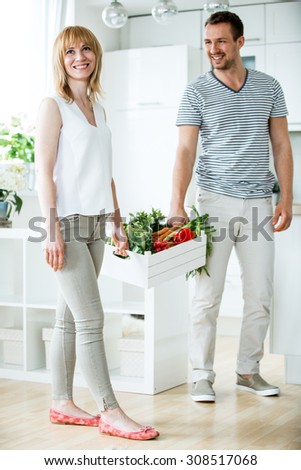 Young couple with vegetable box in kitchen