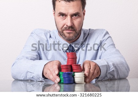 Mature man with poker chips on glass table, placing his bet