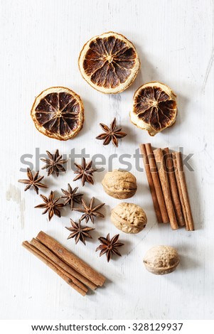 Still life with cinnamon sticks, dried oranges, star anis and walnuts
