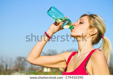 woman drinking water from bottle after fitness sport exercise