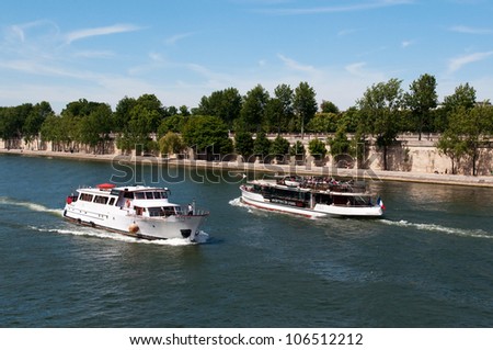 PARIS, FRANCE - MAY 28, 2011: Seine river with tourists ship in Paris on May 28, 2011, France. The Seine is a 776 km long river and an important commercial and tourist waterway within the Paris area