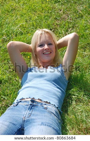 A beautiful young woman asleep in a grassy field