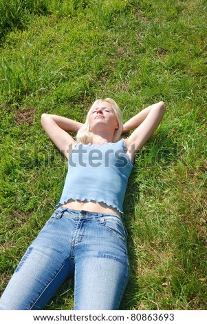 A beautiful young woman asleep in a grassy field