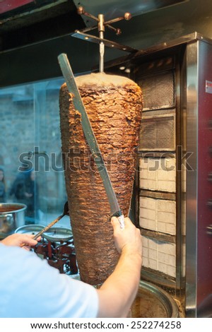 Doner kebab Turkish doner is being cut before serving by chef at restaurant in istanbul