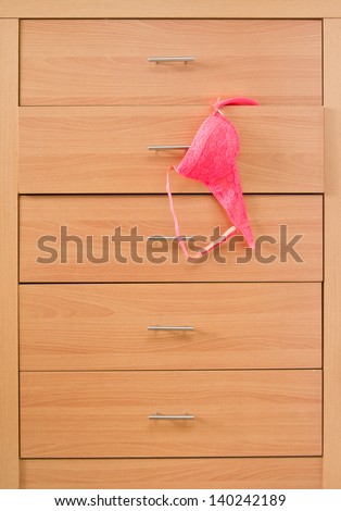 Wooden dresser with pink bra