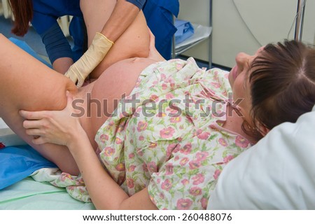 Young woman giving birth in maternity hospital