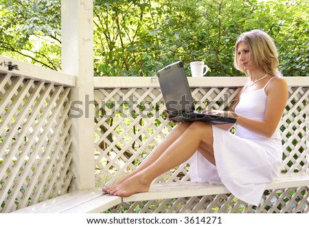 Woman working on computer in the city park and drinking cofee.