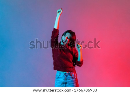 I am champion! Neon light portrait of victorious delighted happy brunette woman raising hands, shouting for joy, screaming celebrating win success, thrilled emotions. indoor studio shot isolated ストックフォト © 