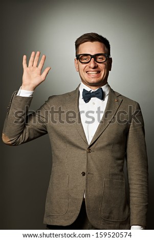 stock-photo-nerd-in-eyeglasses-and-bow-tie-says-hello-against-grey-background-159520574.jpg