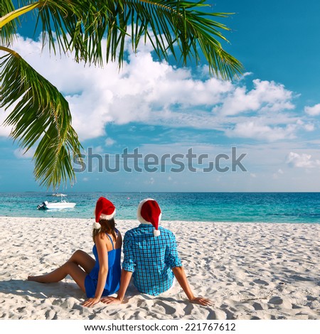 Couple in blue clothes on a tropical beach at christmas