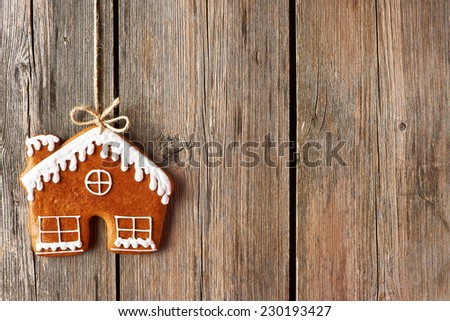 Christmas homemade gingerbread house cookie over wooden background