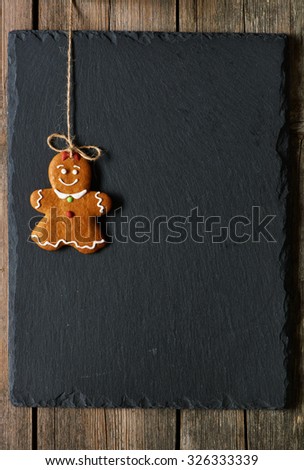 Christmas homemade gingerbread girl over slate background