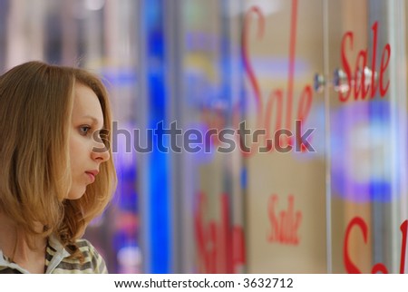 Girl in shopping mall looking on a show-window with \