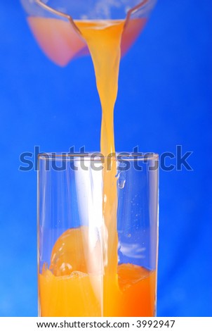 Pouring juice against blue background