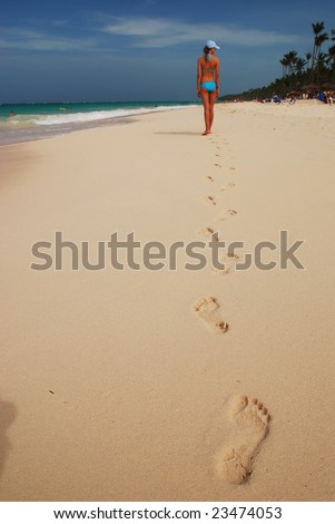 Footprints in the sand on caribbean beach. Focus on first step.