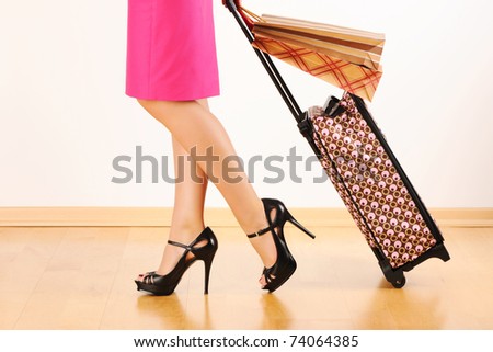 Woman\'s legs and travel suitcase