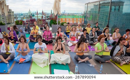 MOSCOW -MAY 31: Surya Namaskar (Sun Salutation) - public yoga classes on the roof of the Ritz-Carlton Hotel, Red Square background on May 31, 2015 in Moscow, Russia