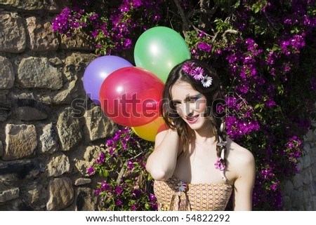 hippie girl with colorful balloons posing for the camera