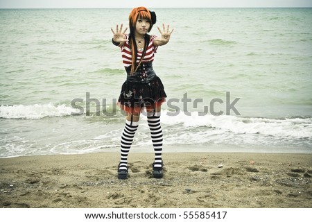 Asian girl disguised as a mime show of hands at the edge of the beach
