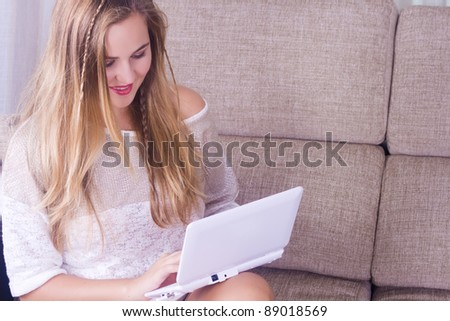 beautiful young woman on the couch with a laptop