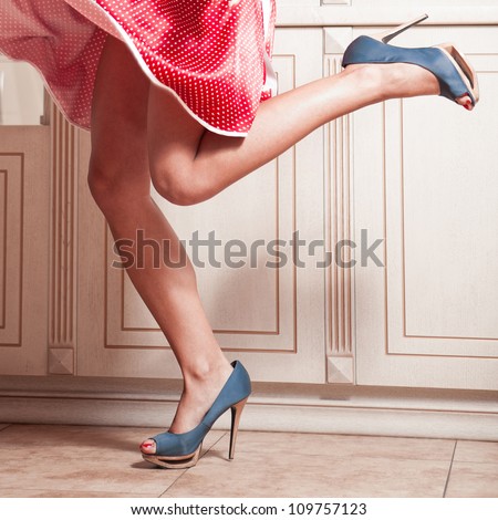 Beautiful woman legs in red dress with blue high heel shoes