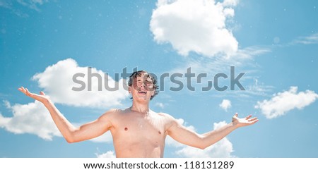Young exhausted athlete splashing and pouring fresh water on his head to refresh during a running trail