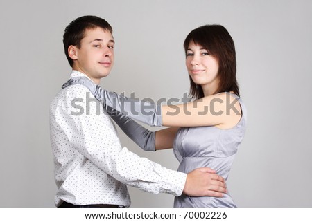 man and woman in evening dress embracing and looking at camera