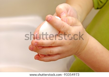 Boy washes with running water and soap hands