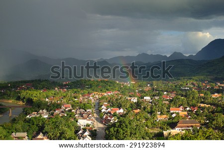 Luang Prabang Laos in late afternoon with coming rain storm with a beautiful rainbow.