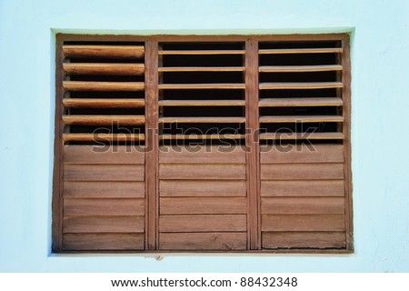 Brown shutters in turquoise wall