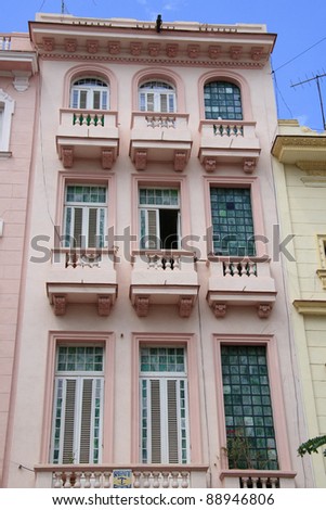 Pink house with balconies and stained glass in Havana backstreet