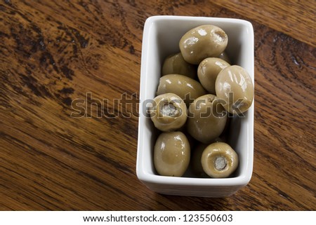Green olives stuffed with blue cheese in a white bowl.