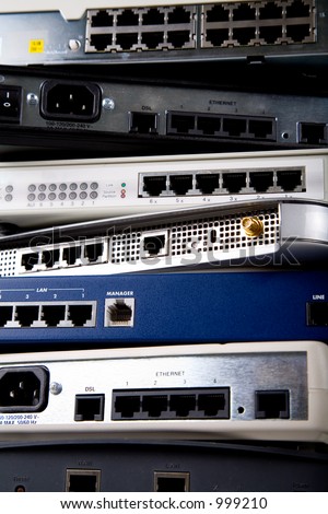 A stack of various network devices including DSL modems, routers, hubs and switches.