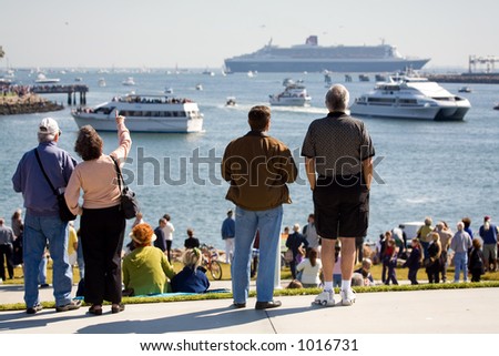 Crowd of people watching Queen Mary 2 meeting with Queen Mary in Long Beach, CA during the historic event.