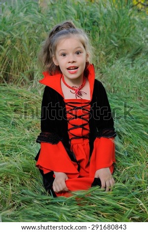 Little Vampire; a little girl outdoors in a fancy vampire costume