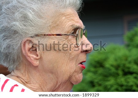 Senior citizen woman in profile with annoyed expression.