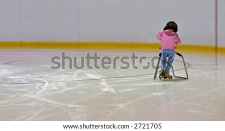 A young girl learning to ice skate uses a brace to stay up