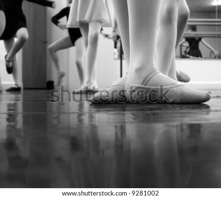 A ballerina practicing moves in the studio with others... a bit of noise exists in the image - original ISO 1600 but i've cleaned it up a good bit tho some noise is still evident. Black and white