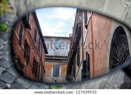 Old Italian architecture reflected in a motorcycle mirror