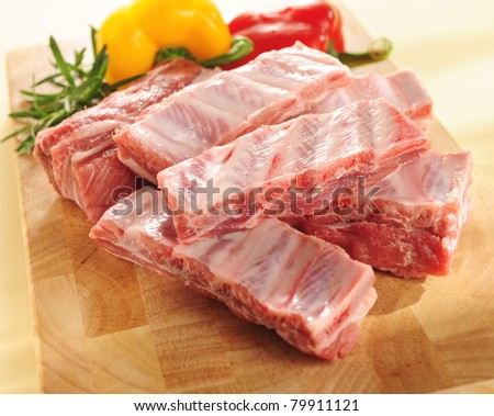 Raw pork ribs on a cutting board and vegetables