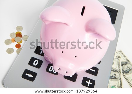 Pig bank and calculator on a white background