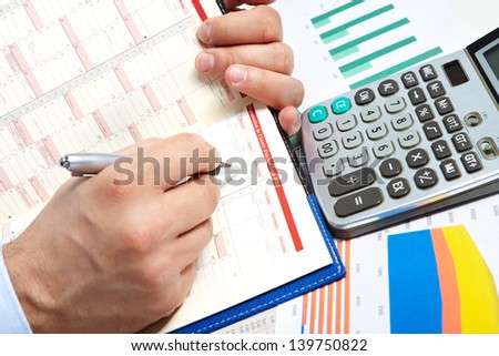 Businessman working with calculator and book in the office