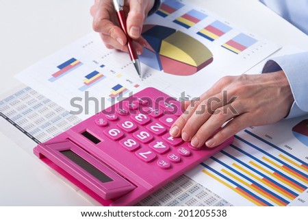 Mature businesswoman and calculator. Calculation at office