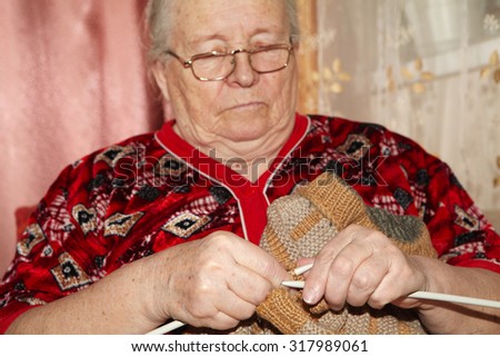 Old woman and knitting sweater. Senior people