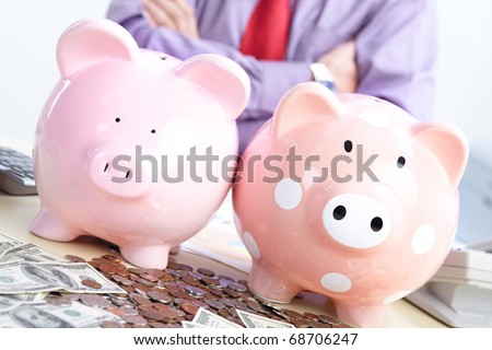 Businessman with money and a pink pig bank