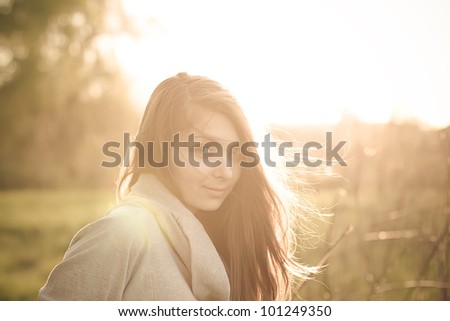 Beautiful young fashionable girl in the rays of spring sun