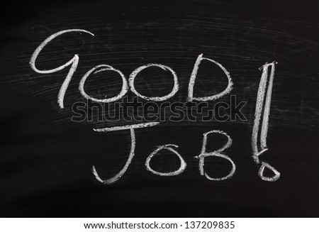 The phrase Good Job with an exclamation mark written on a well used blackboard