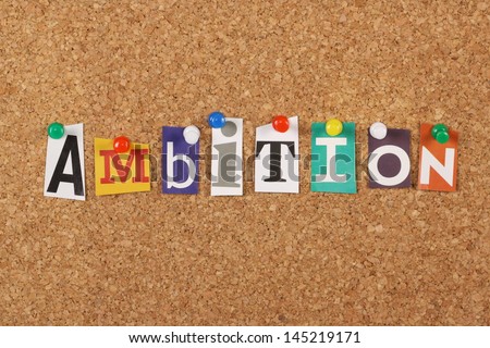 The word Ambition in cut out magazine letters pinned to a cork notice board