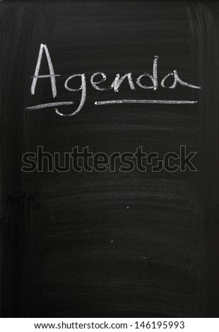 The word Agenda written in chalk at the top of a used blackboard with room for your text. A concept for planning efficient and productive business meetings